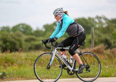 Woman cycling on a Cannondale bike on a scenic trail in nature during daytime.