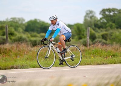 High-performance cyclist riding a road bike on scenic rural trail for outdoor recreation.