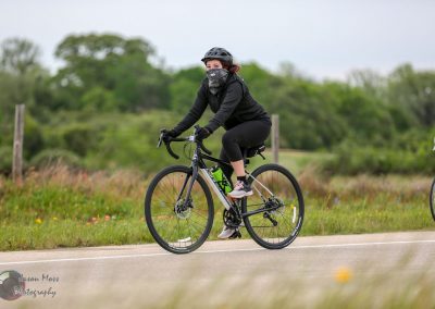 Comfortable women cycling on scenic trail with Bluebonnet Express e-bike in Texas spring.