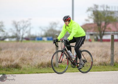 Bright yellow cyclist jacket on a road bike during daytime.