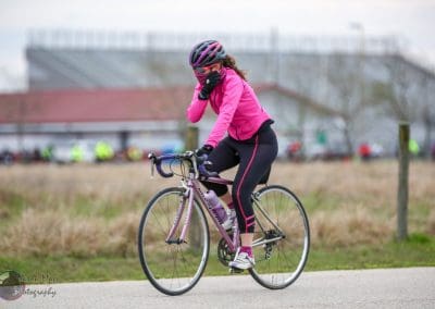 Bike riding with a pink jacket and helmet, promoting Bluebonnet Express cycling event and outdoor fitness.