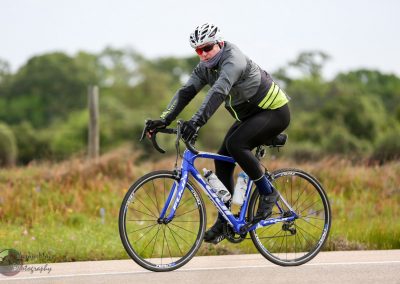 Bluebonnet Express cycling event rider on a road bike in outdoor nature setting.