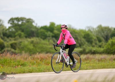 Bright pink cyclist gear during Bluebonnet Express bike ride in Texas countryside, showcasing outdoor cycling event.