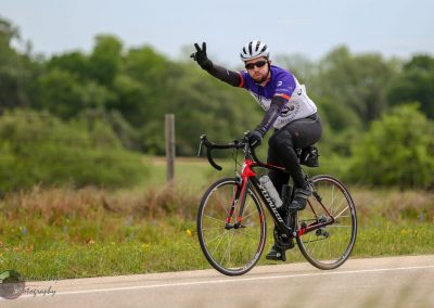 Man riding a Specialized road bike during cycling event on scenic outdoor trail.