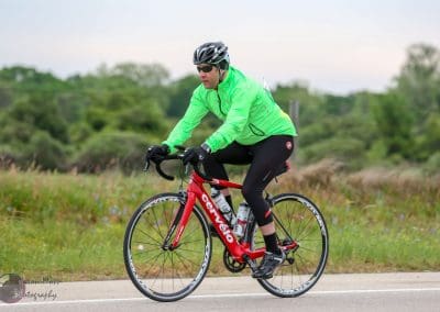 Bright green cyclist jacket on a Cannondale road bike during Bluebonnet Express event, showcasing endurance cycling.