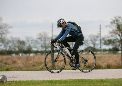 Rider on a sports bicycle riding outdoors on a cloudy day at Bluebonnet Express.