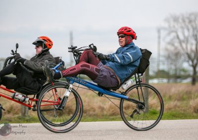 All-terrain recumbent bike with riders enjoying outdoor cycling adventure.