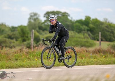National park scenic view with a cyclist riding a road bike on a sunny day, promote Texas bike tours and outdoor recreation.