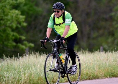 Man riding a bike along a scenic trail on a sunny day during a Bluebonnet Express event.