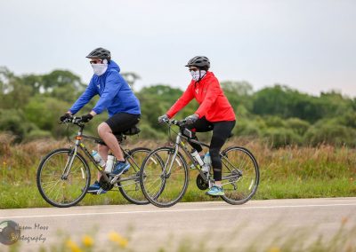 All-season bike ride on the Bluebonnet Express bike trail with cyclists wearing masks, helmets, and weather-appropriate gear.