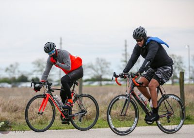 High-performance cyclists riding on a paved trail during an overcast day, showcasing Bluebonnet Express bike comfort and durability.