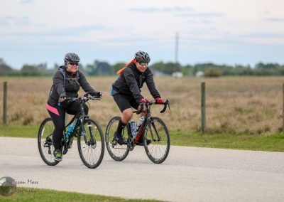 Active cyclists riding bikes on scenic rural trail for outdoor fitness and adventure.