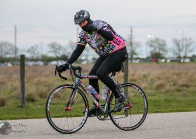Vibrant cyclist in Bluebonnet Express gear riding on scenic outdoor trail.
