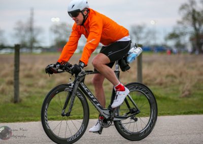 Vibrant cyclist riding a bike outdoors in a scenic park setting.