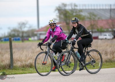 Brightly dressed women riding bikes together during daytime in an outdoor setting.