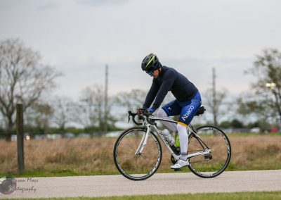 High-performance cyclist riding a road bike during training or race by Bluebonnet Express.