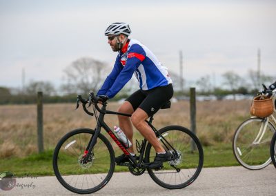 Men's cycling with road bicycle in scenic outdoor setting for Bluebonnet Express event in Texas.