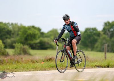 Vibrant cyclist riding a road bike during Bluebonnet Express event in Texas.