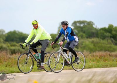 Brightly dressed cyclists enjoying a scenic ride on Bluebonnet Express bike trail.