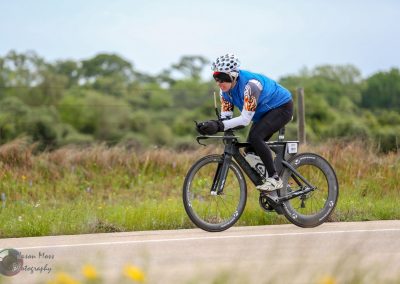 Fast electric bike rider on a scenic rural trail, promoting Bluebonnet Express bike services for eco-friendly commuting.