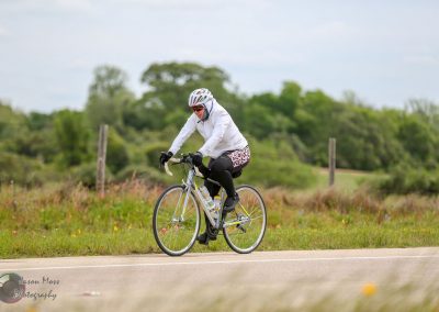 Bright woman cycling on a scenic bike route along the Bluebonnet Express trail in Texas for outdoor fitness.
