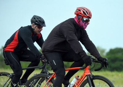 Velo cyclists riding on a rural trail during daytime, showcasing the Bluebonnet Express bike route.