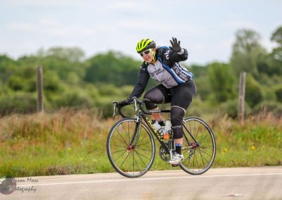 Cyclist riding a road bike on a scenic rural route for Bluebonnet Express event.