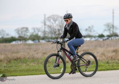 Comfortable woman riding Black and Pink Mountain Bike for outdoor exercise and fitness.
