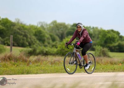 Smooth road biking with woman cyclist in nature during daytime.