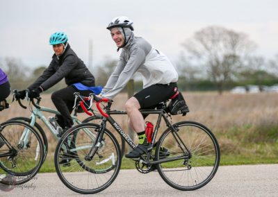 Brightly dressed cyclists riding bicycles outdoors on a cloudy day for active lifestyle.