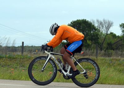 High-performance cyclist riding a specialized bike on rural road during outdoor cycling event.