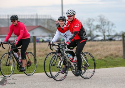 Vibrant cyclists riding together on a scenic bike path during daytime.