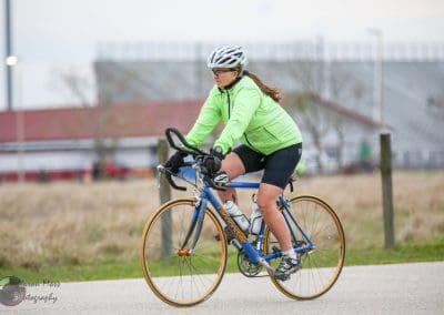 Rider on Bluebonnet Express cycling bike, outdoor sports activity, sunny day, athletic endurance, fitness cycling.