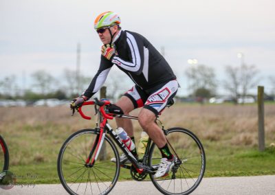 Velo cyclist riding on a trail during daytime, promoting outdoor biking events and fitness.