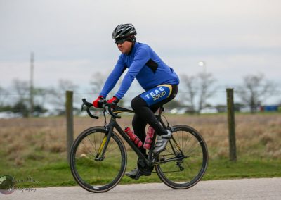 Cyclist riding a road bike in Bluebonnet Express event, wearing gear for endurance cycling.