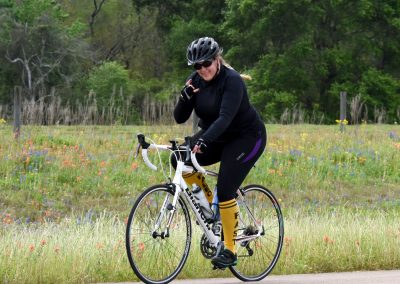 Vibrant cyclist riding in scenic meadow on Bluebonnet Express bike trail during spring.