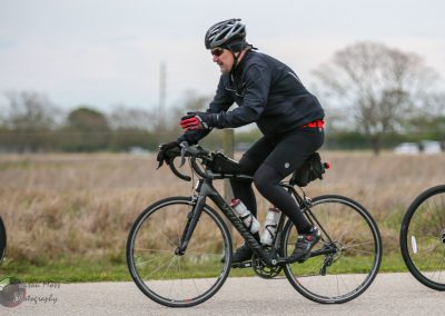 Load-bearing, vibrant athlete cycling in outdoor race, emphasizing endurance and fitness.