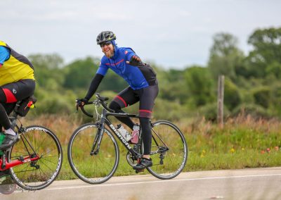 Vibrant cyclist riding Bluebonnet Express bike on scenic outdoor trail, promoting active lifestyle and eco-friendly transportation.