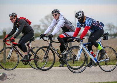 Middle-aged cyclists riding bikes outdoors in casual gear.
