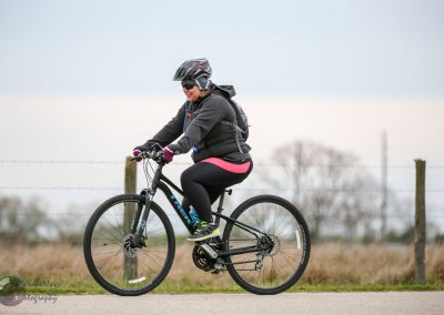 Vibrant woman cycling outdoors on a mountain bike, promoting Bluebonnet Express cycling tours.