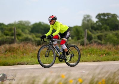 Bright yellow cyclist jersey on Bluebonnet Express bike route, showcasing scenic Texas countryside.