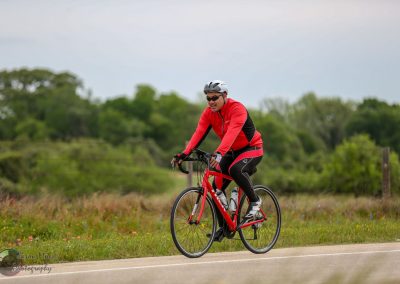 Bright red bicycle on scenic countryside trail with cyclist enjoying outdoor ride.