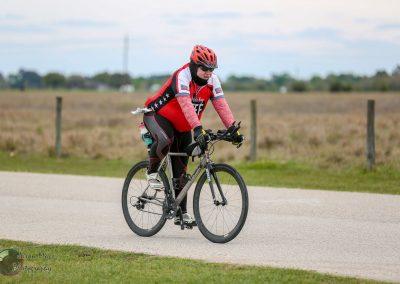 Vegan cyclist riding on scenic rural road, promoting eco-friendly biking and outdoor exercise.