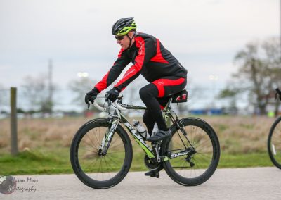 Fast cyclist on Bluebonnet Express bike trail during daytime outdoor ride.
