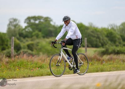 Bright man happy riding bike on scenic countryside, Bluebonnet Express cycling adventure.