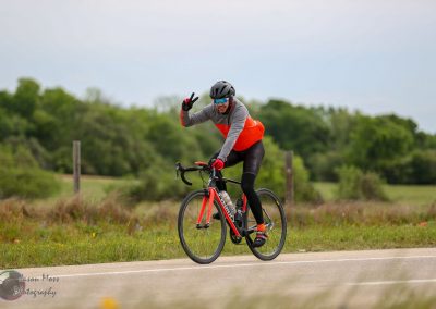 Vast cyclist riding on scenic countryside, promoting Bluebonnet Express biking adventures.