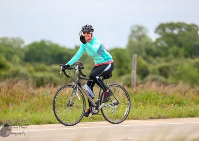Vibrant cyclist riding on scenic route, enjoying eco-friendly transportation with Bluebonnet Express.