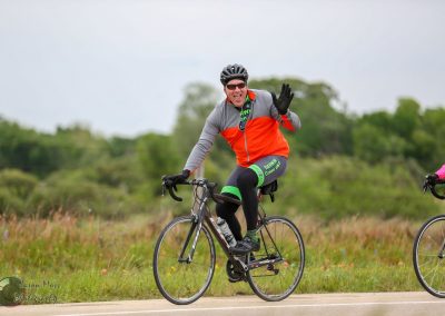 Vibrant cyclist riding along scenic Texas countryside during Bluebonnet Express event.