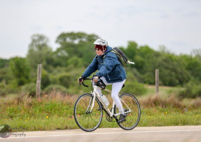Bright woman riding an e-bike in nature, outdoor cycling, eco-friendly transportation, Bluebonnet Express bike.