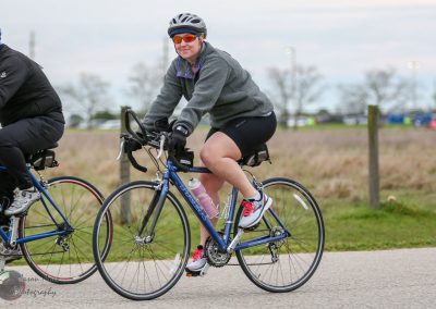 Bicycle rider enjoying outdoor cycling on a paved path during daytime, promoting health and eco-friendly transportation.